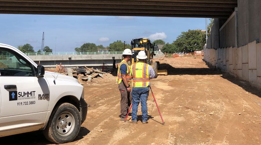 Employees Performing a Survey on a Construction Site