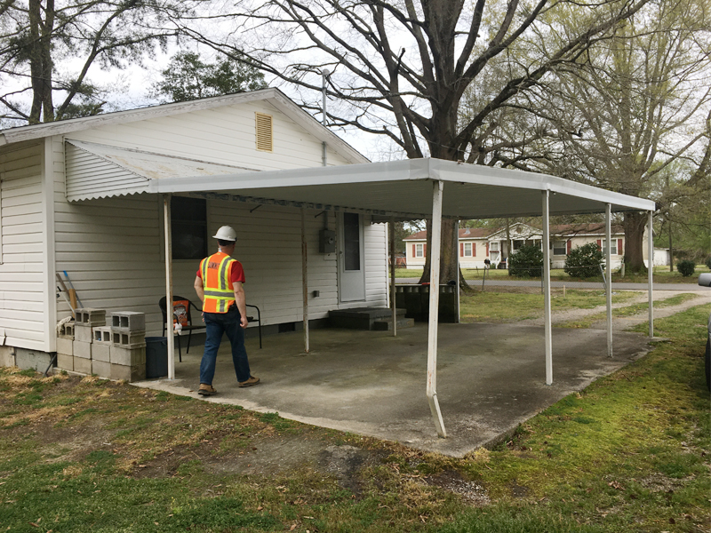 Photo of a Summit worker assessing a house's drive port as a part of the Edgecombe HMGP project.