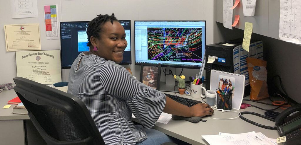 Person Smiling and Working on a Computer