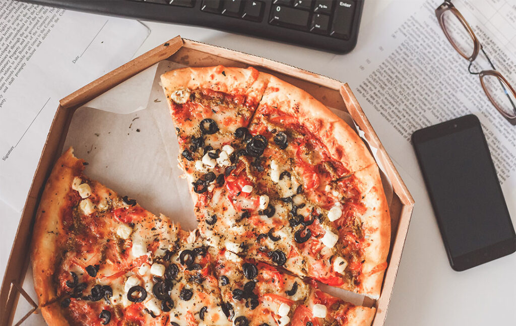 Box of Pizza on top of Papers