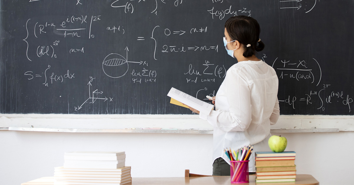 Teacher in a classroom wearing a mask