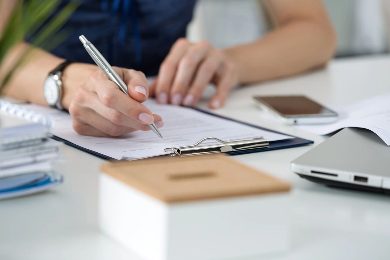 Woman writing on a clipboard