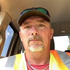 A headshot of Pinnacle Award Winner Robert L. where he is looking directly at the camera. He is dressed in his PPE vest and has a hat on.