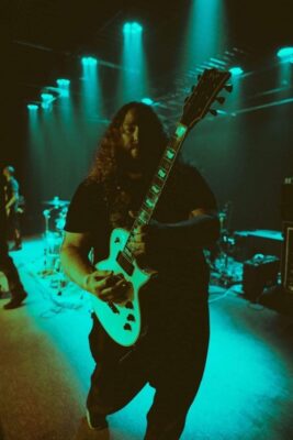 Wes C. performing on stage with his guitar.