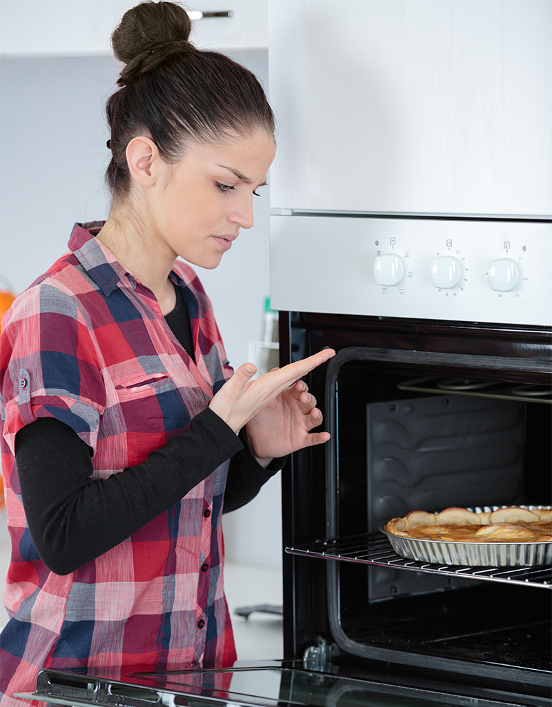 Woman checking hand after burning on stove